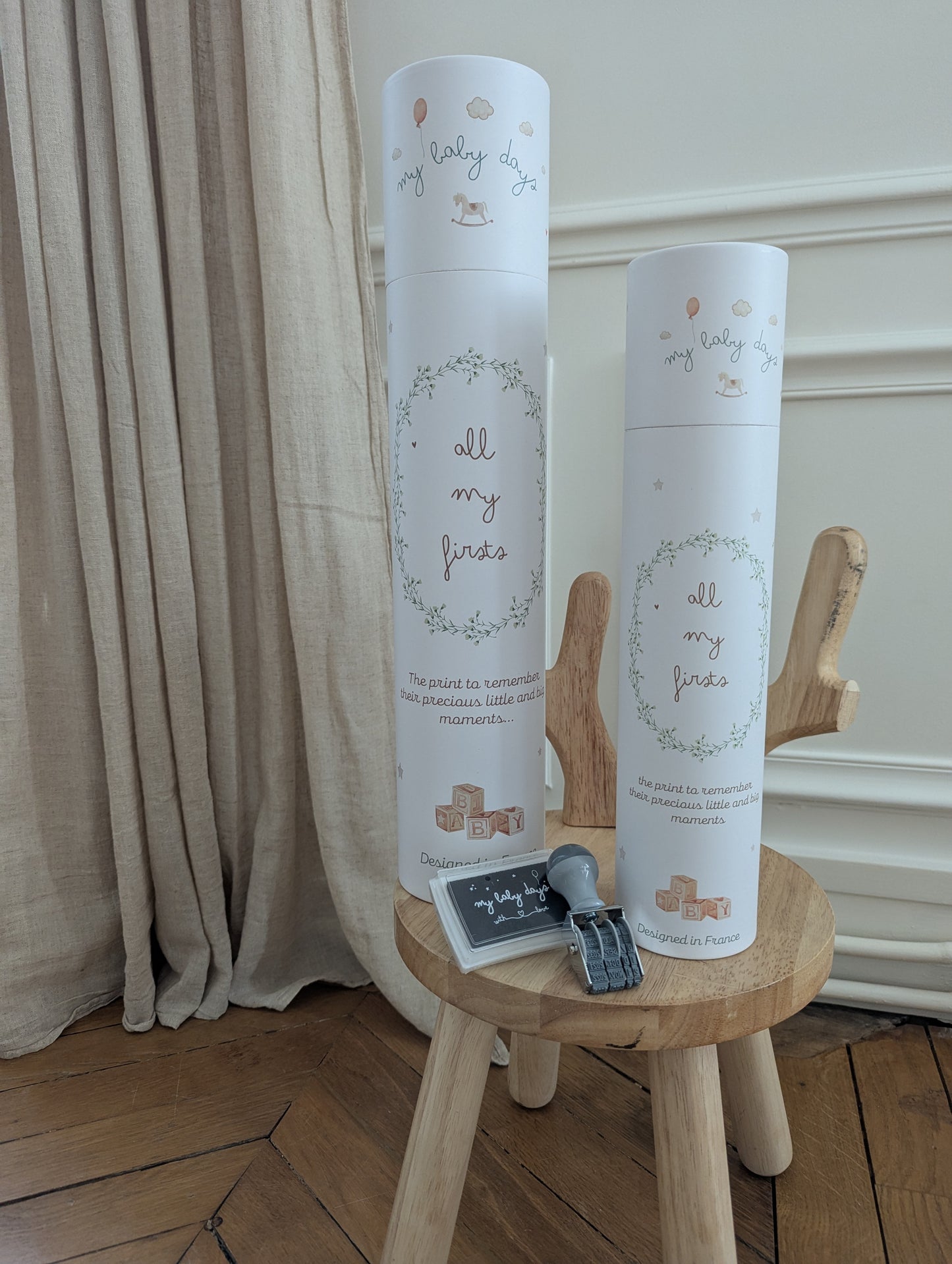 All My Firsts prints in A2 and A3 tubes on stool with stamp